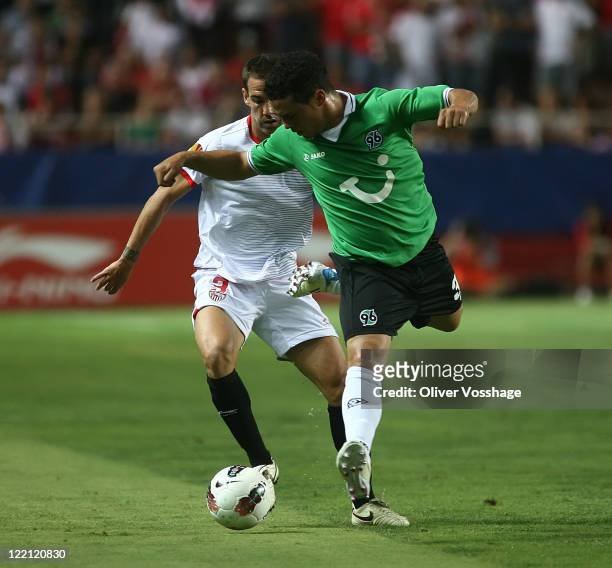 Fernando Navarro of FC Sevilla and Manuel Schmiedebach of Hannover 96 battle for the ball during the UEFA Europa League Play-Off second leg match...