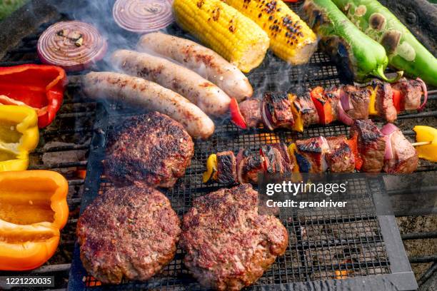 un beau grill mélangé, de la viande et des légumes frais disposés sur un gril de charbon de bois - burger on grill photos et images de collection