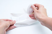 Woman hands taking wet cleaning antibacterial wipes out of package, white background, hygiene and body care concept