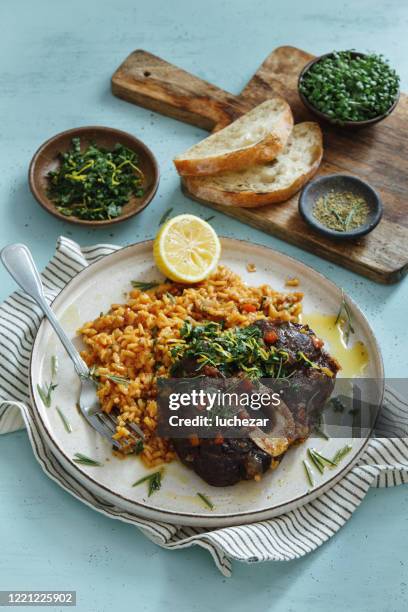 traditioneller italienischer osso buco mit cremigem safranrisotto und gremolata - osso bucco stock-fotos und bilder