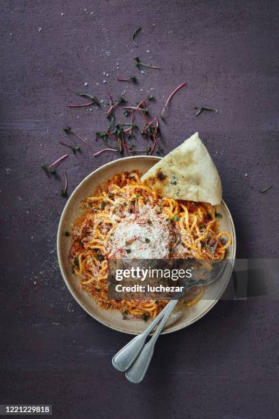 classic spaghetti bolognese with parmesan cheese on purple background - pasta with bolognese sauce stock pictures, royalty-free photos & images