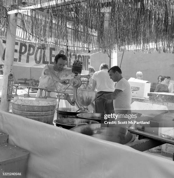 View of two men mixing dough at a zeppole and calzone stand on Mulberry Street during the Feast Of San Gennaro Festival, in the Little Italy...