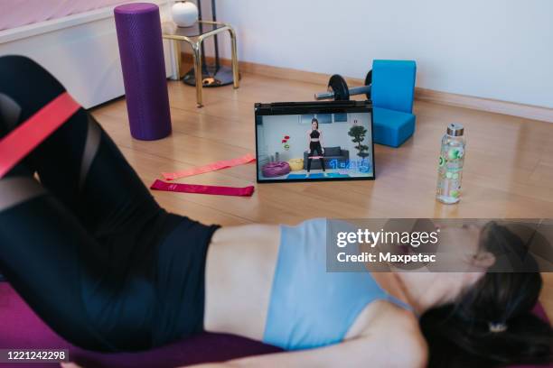 young woman doing online hiit training at home - hiit stock pictures, royalty-free photos & images