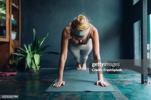 working out at home: beautiful fit blonde woman doing a plank - cobra stretch stock pictures, royalty-free photos & images