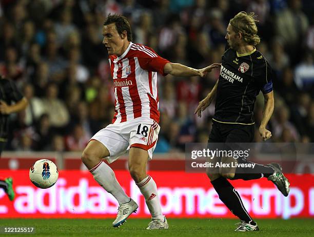 Dean Whitehead of Stoke City holds off a challenge from Roland Battig of FC Thun during the UEFA Europa League play-off second leg match between...