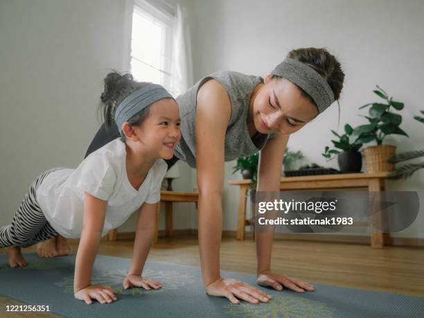 mutter und tochter beim yoga - zuhause wohlfühlen stock-fotos und bilder