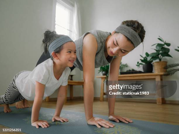 mother and daughter doing yoga - sports training stock pictures, royalty-free photos & images
