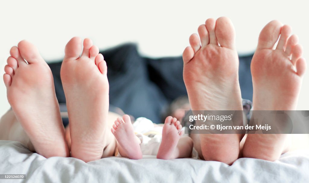 Feet of family in bed