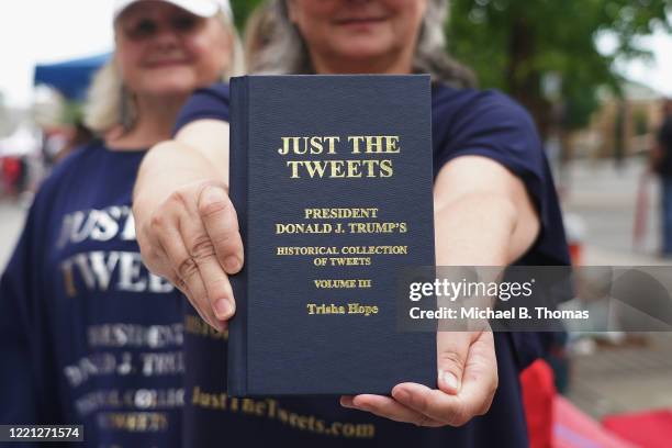 Woman holds a book of compiled tweets of President Donald Trump prior to a campaign rally for President Donald Trump at the BOK Center on June 20,...