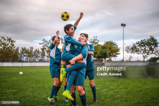 blue jersey boy voetballers juichen en vieren - voetbalcompetitie sportevenement stockfoto's en -beelden