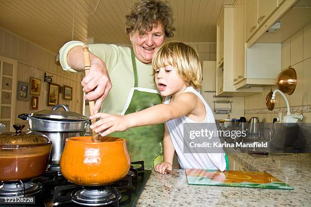 young boy cooking  with grandma - gas cooking stock pictures, royalty-free photos & images