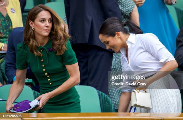 Catherine, Duchess of Cambridge walks with Meghan, Duchess of Sussex into the Royal Box on Centre Court ahead of the Ladies Singles Final between...