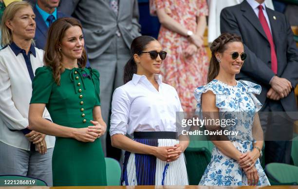 Catherine, Duchess of Cambridge stands with Meghan, Duchess of Sussex, and Pippa Middleton in the Royal Box on Centre Court after the Ladies Singles...