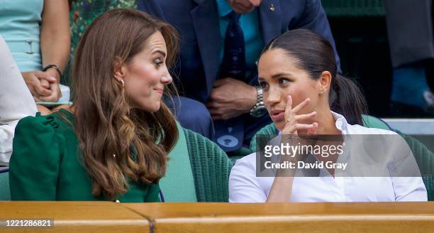 Catherine, Duchess of Cambridge talks with Meghan, Duchess of Sussex in the Royal Box on Centre Court ahead of the Ladies Singles Final between...
