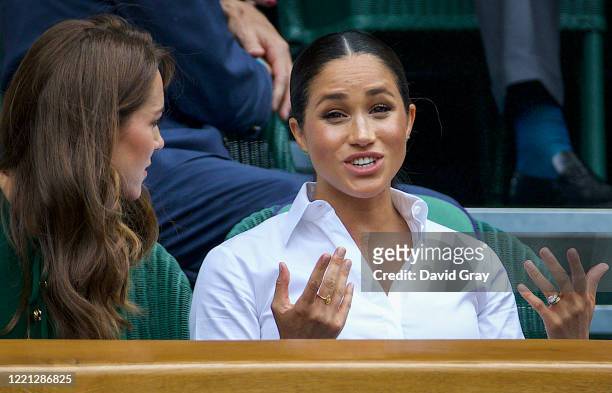 Catherine, Duchess of Cambridge talks with Meghan, Duchess of Sussex into the Royal Box on Centre Court ahead of the Ladies Singles Final between...
