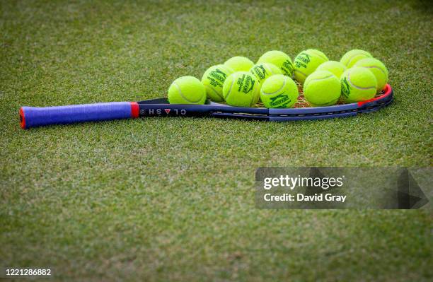 Tennis balls sit atop a racquet on a practice court during the Wimbledon Lawn Tennis Championships at the All England Lawn Tennis and Croquet Club at...