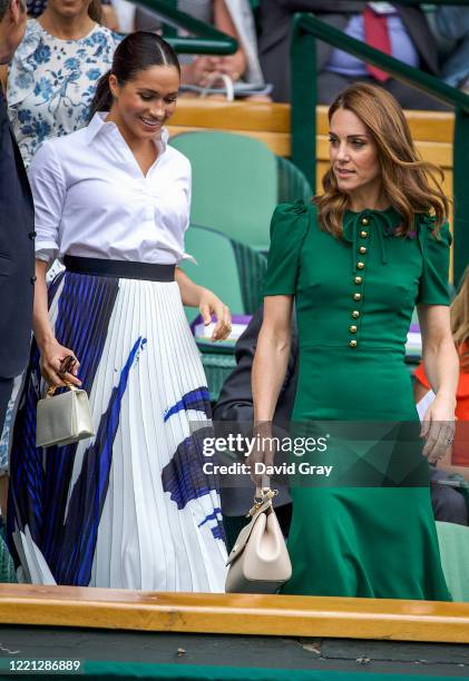 Catherine, Duchess of Cambridge walks with Meghan, Duchess of Sussex into the Royal Box on Centre Court ahead of the Ladies Singles Final between...
