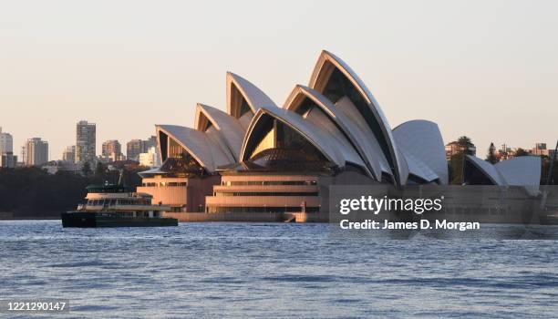 Sydney Harbour taking in the Harbour Bridge, Opera House and ferries at sunrise during the COVID-19 pandemic on April 20, 2020 in Sydney, Australia.