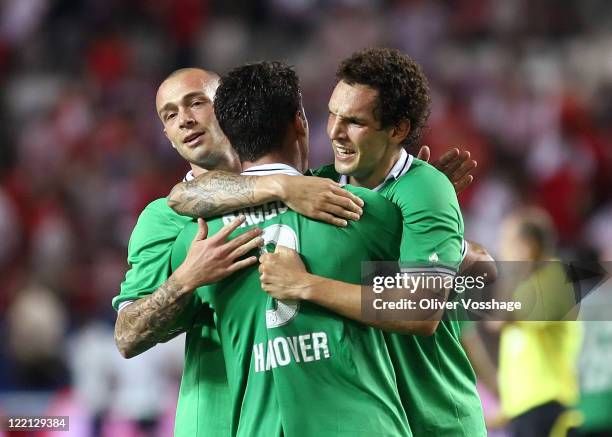 Christian Pander, Henning Hauger and Emanuel Pogatetz of Hannover 96 celebrate victory at the end of the Game the UEFA Europa League Play-Off second...