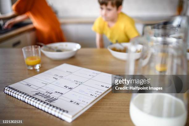 diary or personal organizer on table in kitchen, morning stress of family with children at home. - meal plan fotografías e imágenes de stock