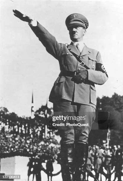 Adolf Hitler , dressed in military attire and giving the Nazi salute, early twentieth century.