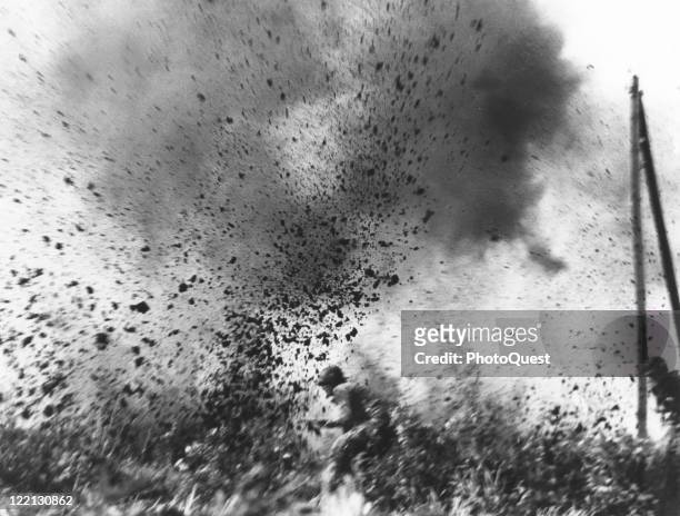 View of paratroopers as they attack through shell bursts fired from German 88 mm artillery during Operation Market Garden in Holland, 1945.