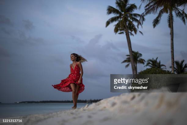 happy woman in a dress running on the beach in the evening. - beautiful woman stock pictures, royalty-free photos & images