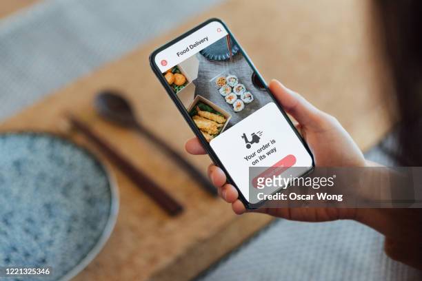 ordering food online at home with smartphone - human hand stock pictures, royalty-free photos & images