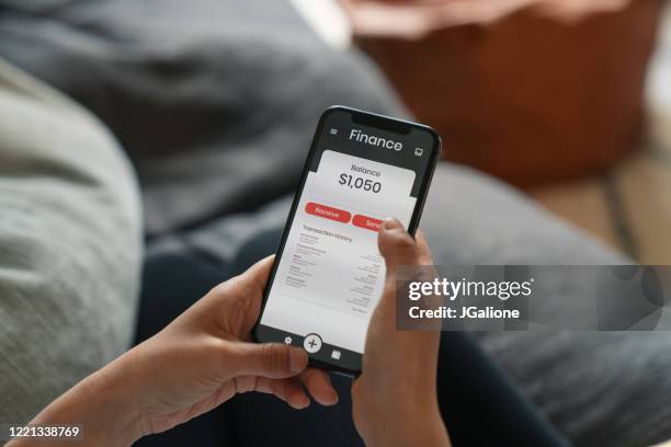 nahaufnahme einer frau mit einer finanz-app auf einem smartphone - kontoauszug stock-fotos und bilder