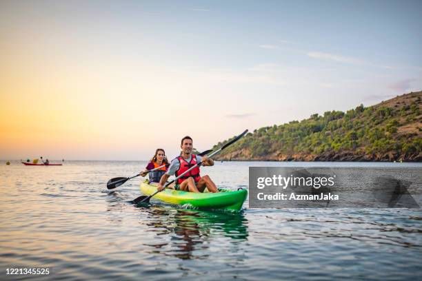 fit friends paddling kayak fuera de la costa brava en dawn - kayak fotografías e imágenes de stock