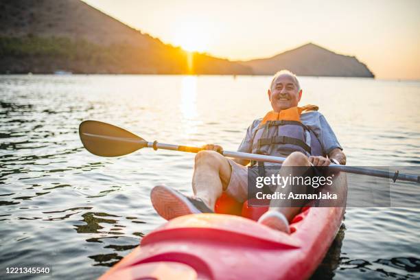 smiling senior kayaker resting at end of morning paddle - life jacket isolated stock pictures, royalty-free photos & images