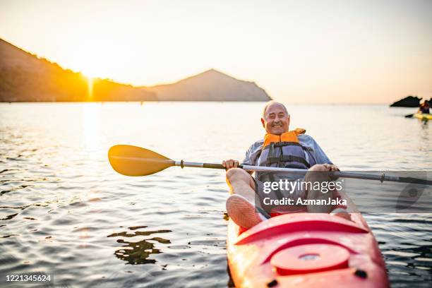 smiling senior kayaker resting at end of morning paddle - life jacket isolated stock pictures, royalty-free photos & images