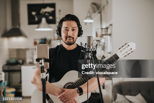 Portrait of a Japanese guitar player at home studio