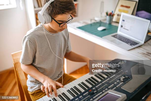 teenage boy having online keyboard lesson - keyboard musical instrument child stock pictures, royalty-free photos & images