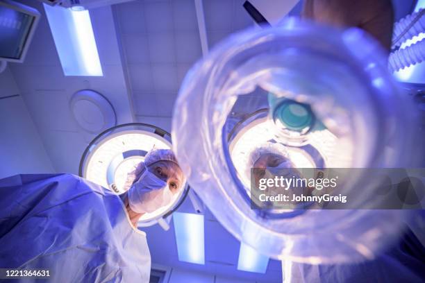 patient point of view of anesthesiologist lowering mask - anesthesiologist imagens e fotografias de stock