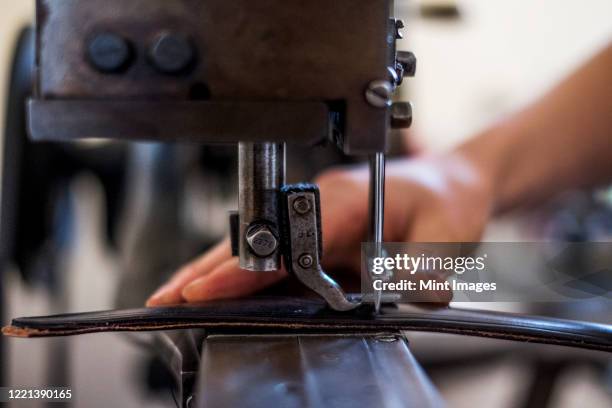 close up of person sewing piece of leather to make a saddle. - maroquinerie photos et images de collection