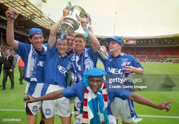 Everton goal scorer Paul Rideout holds the trophy aloft with Barry Horne as they celebrate with team mates Gary Ablet Matt Jackson Daniel Amokachi...