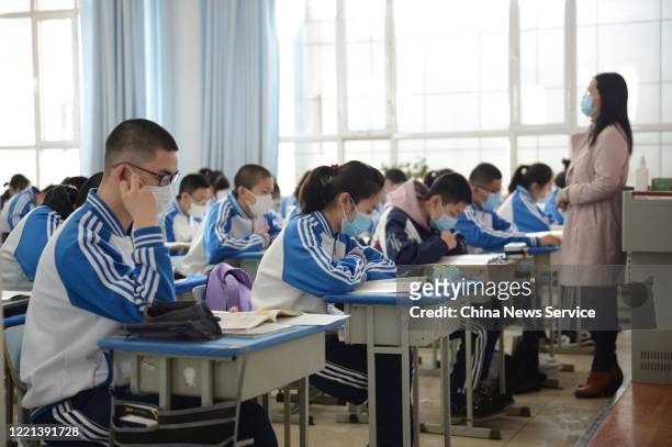 Students wearing face masks have a class at No.One Middle School on April 27, 2020 in Huhhot, Inner Mongolia Autonomous Region of China. Students in...