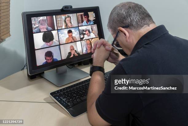 friends in their homes on a conference call and praying together for the good of all - lowering the head - praying stock pictures, royalty-free photos & images