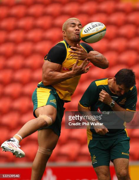 Digby Ioane of the Wallabies practices his skills alongside coach Robbie Deans during the Australian Wallabies Captain's Run at Suncorp Stadium on...