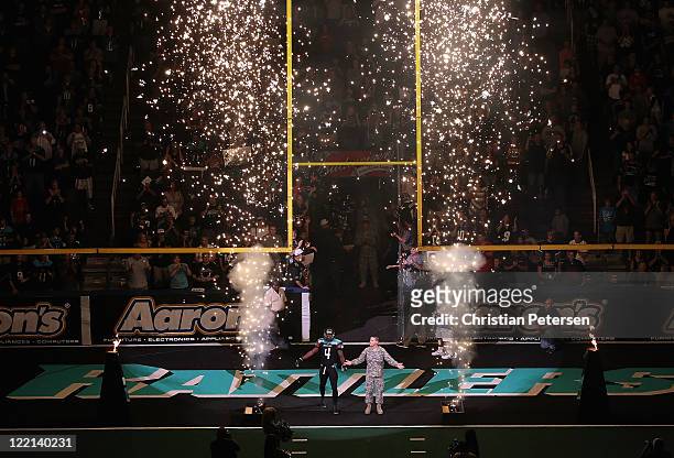 Virgil Gray of the Jacksonville Sharks runs out onto the field with a member of the Army National Guard for introductions to the ArenaBowl XXIV at US...