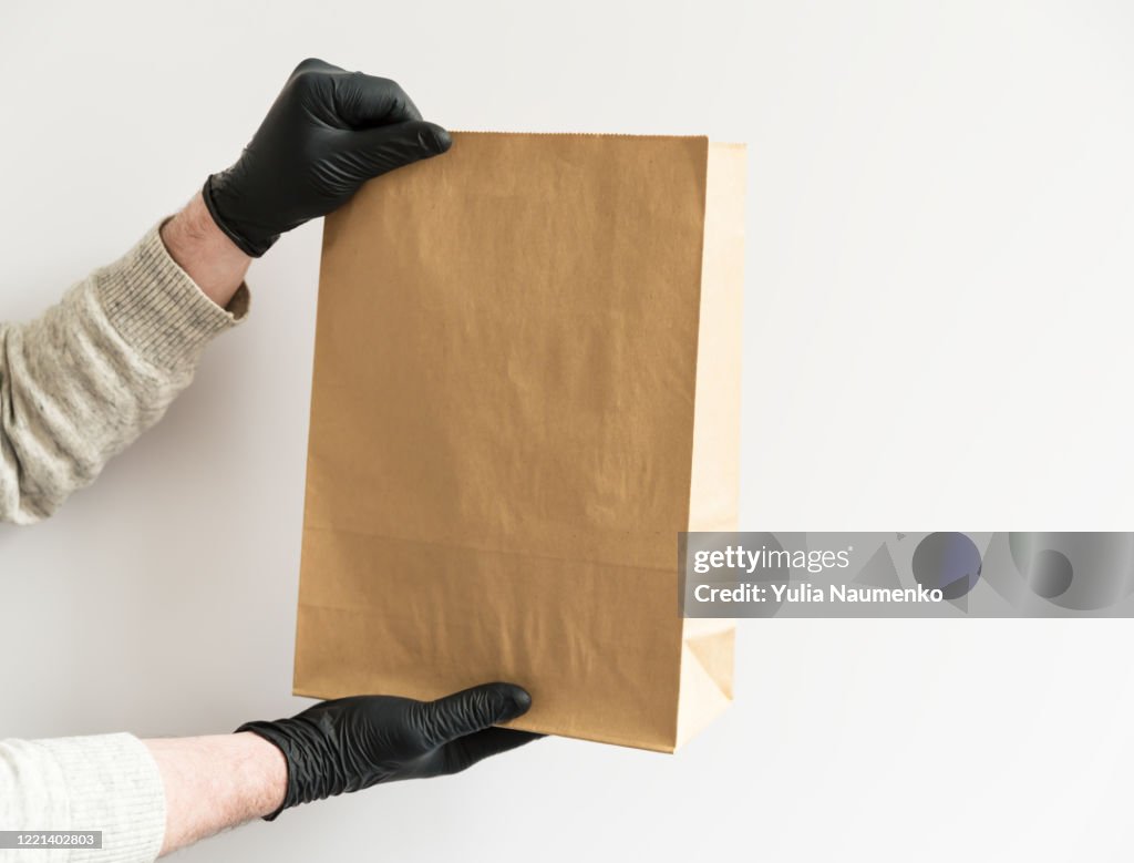 https://media.gettyimages.com/id/1221402803/photo/close-up-of-the-hands-of-a-man-in-black-gloves-holding-paper-bag-white-background-ordering.jpg?s=1024x1024&w=gi&k=20&c=zM0F0UoMl4PkzDrV2-uahcFm-tdGreiB7DwuF3RCAtM=