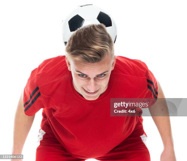caucasian young male soccer player in front of white background wearing soccer uniform and holding soccer ball and playing soccer - sport and using sports ball - soccer player on white stock pictures, royalty-free photos & images