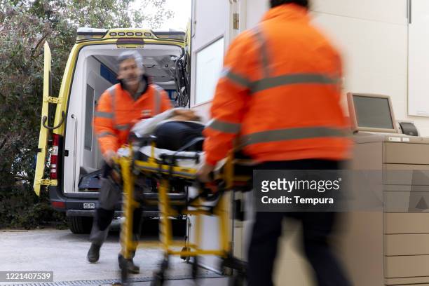 blur motion view of a hospital gurney exiting an ambulance. - ambulance arrival stock pictures, royalty-free photos & images