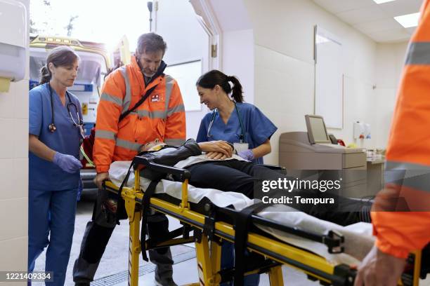 een verpleegster troost een auto-ongeluk slachtoffer bij aankomst op de eerste hulp. - accident hospital stockfoto's en -beelden