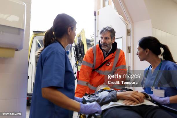emergency staff is briefing the nurses on the patients condition. - ambulance arrival stock pictures, royalty-free photos & images