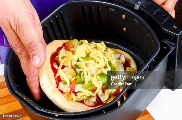 hot slices of pizza in black air fryer isolated - airfryer stock pictures, royalty-free photos & images