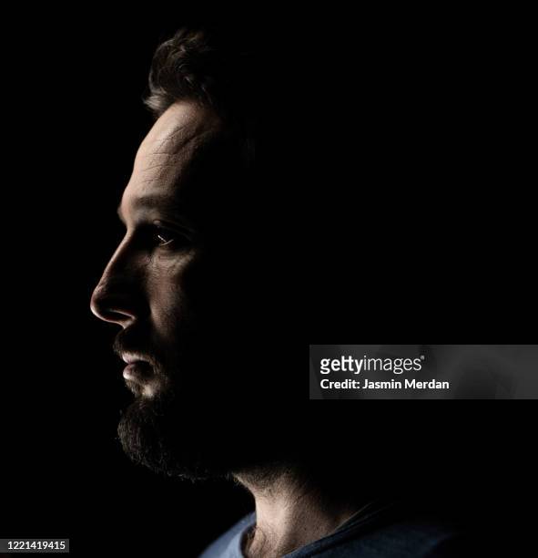 portrait of a man in dark background - vista laterale foto e immagini stock