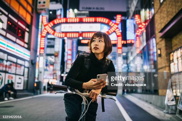 frau arbeitet als fahrradkurierin - tokyo japan stock-fotos und bilder