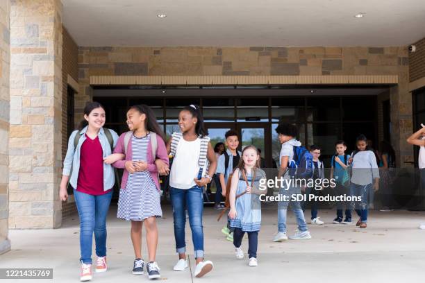 schoolgirls leave school building together - last day of school stock pictures, royalty-free photos & images
